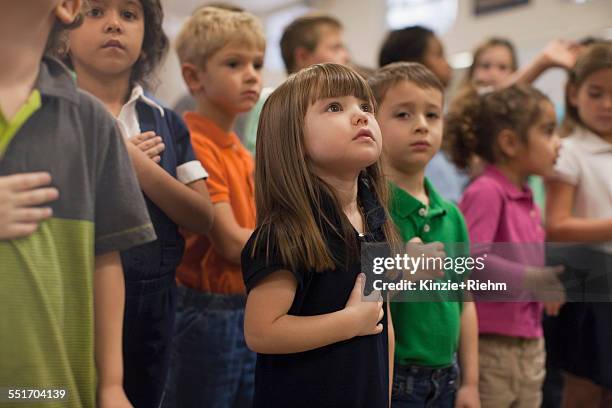 children reciting pledge of allegiance in school - 胸に手を当てる ストックフォトと画像