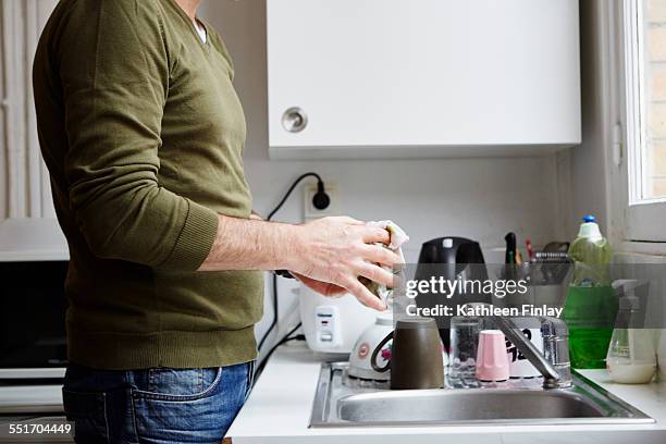 mature man washing up in kitchen - pano da loiça imagens e fotografias de stock