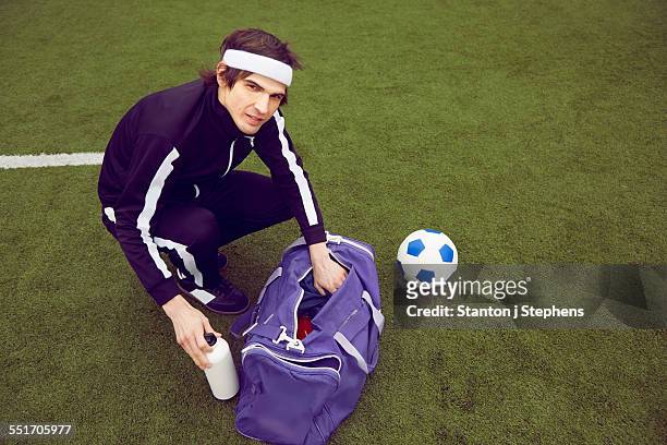 male soccer player preparing to play on soccer pitch - sporttas stockfoto's en -beelden