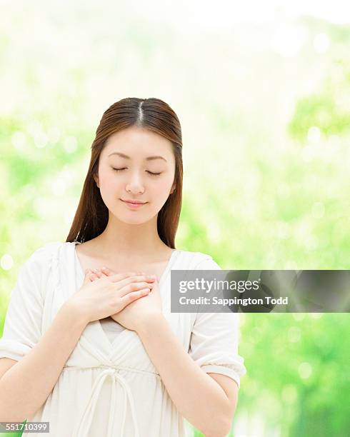 woman with eyes closed - hand on chest stock pictures, royalty-free photos & images