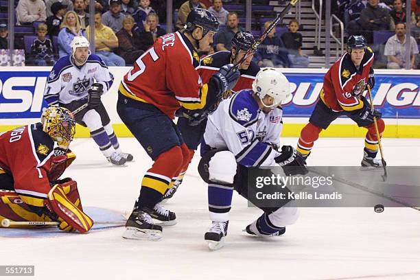 Defenseman Brad Ference and goaltender Roberto Luongo of the Florida Panthers watch as Steve Heinze of the Los Angeles Kings deflects a puck in front...