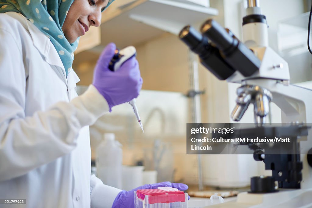 Female science student pipetting samples in lab