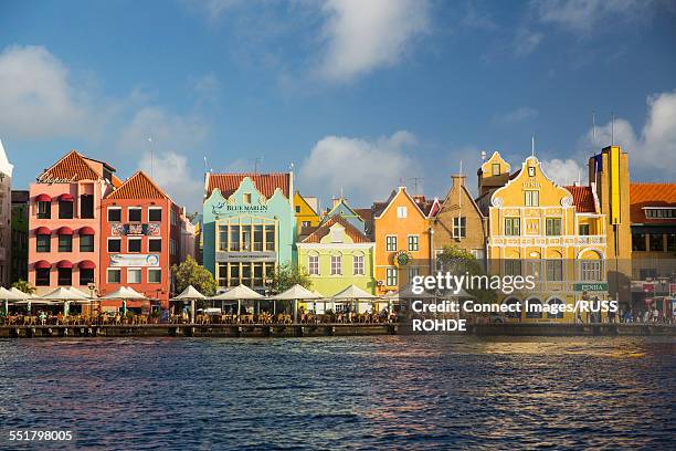 row of traditional multi colored town houses on waterfront, punda, willemstad, curacao, caribbean - willemstad stock pictures, royalty-free photos & images