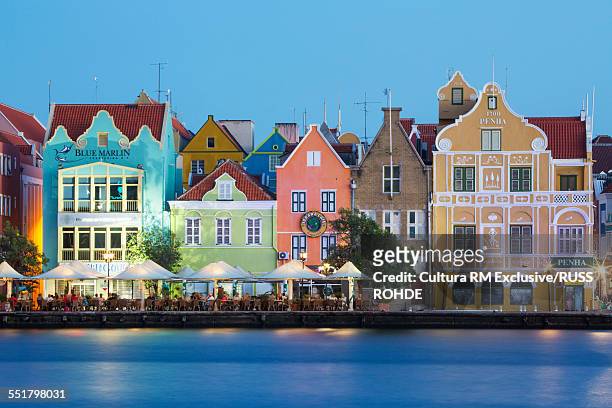 traditional multi colored town houses on waterfront at dusk, punda, willemstad, curacao, caribbean - curacao fotografías e imágenes de stock