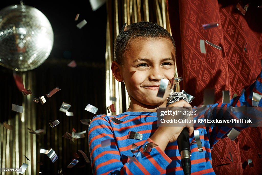 Boy with microphone waving on stage