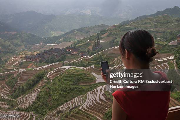 young woman taking photo, longsheng, guangxi province, china - cultura orientale photos et images de collection