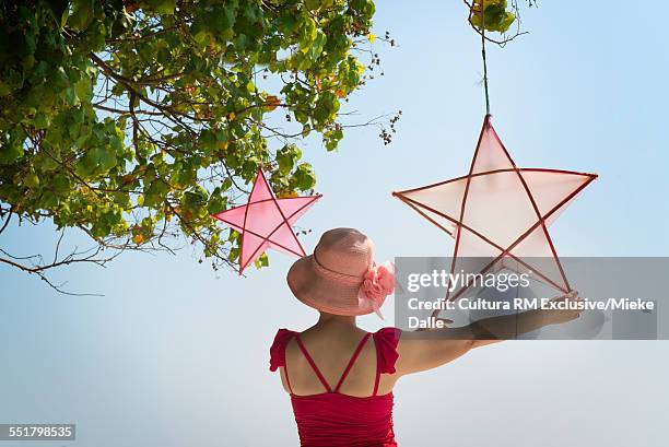 mature woman holding star shape decoration - rm creatief stockfoto's en -beelden