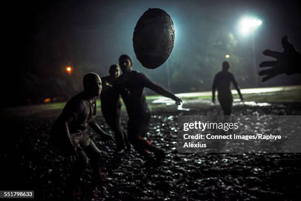 lateral pass, defensive line on muddy field - venues and sites stock pictures, royalty-free photos & images