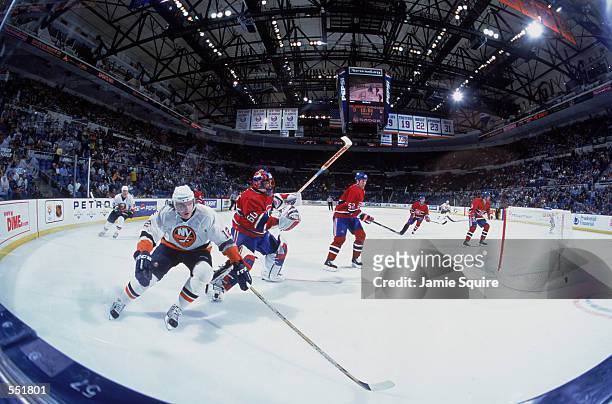 Left wing Oleg Kvasha of the New York Islanders and goaltender Jose Theodore of the Montreal Canadiens skate on the ice during the NHL game at the...