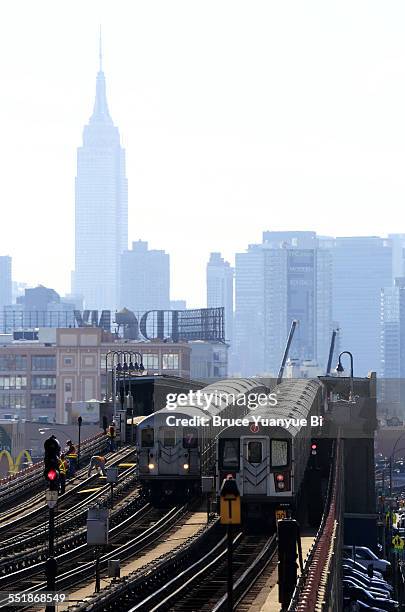 no.7 elevated subway train with manhattan skyline - new york city subway stock-fotos und bilder