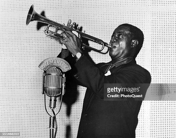 American Jazz musician Louis Armstrong plays trumpet during a Voice of American radio broadcast, Washington DC, 1960.
