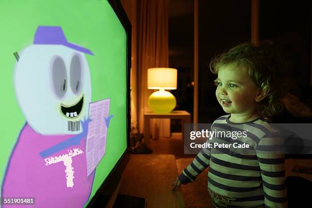 little girl watching a cartoon on tv. - pink tv stock pictures, royalty-free photos & images