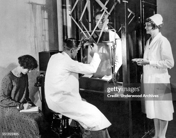 Physician doing a fluoroscope examination on a male patient at John Harvey Kellogg's Battle Creek Sanitarium, Battle Creek, Michigan, circa 1928.