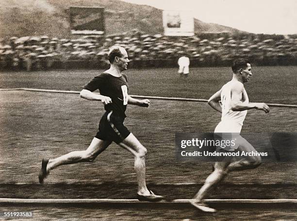 Paavo Nurmi, the flying Finn, as he was about to pass German runner Max Danz in the 10,000 meter run at the Berlin Sports Club, Berlin, Germany, 1931.