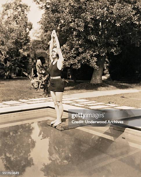 Warner Brothers movie actress Patsy Ruth Miller exhibits her perfect form at the end of a diving board, Hollywood, California, circa 1924.