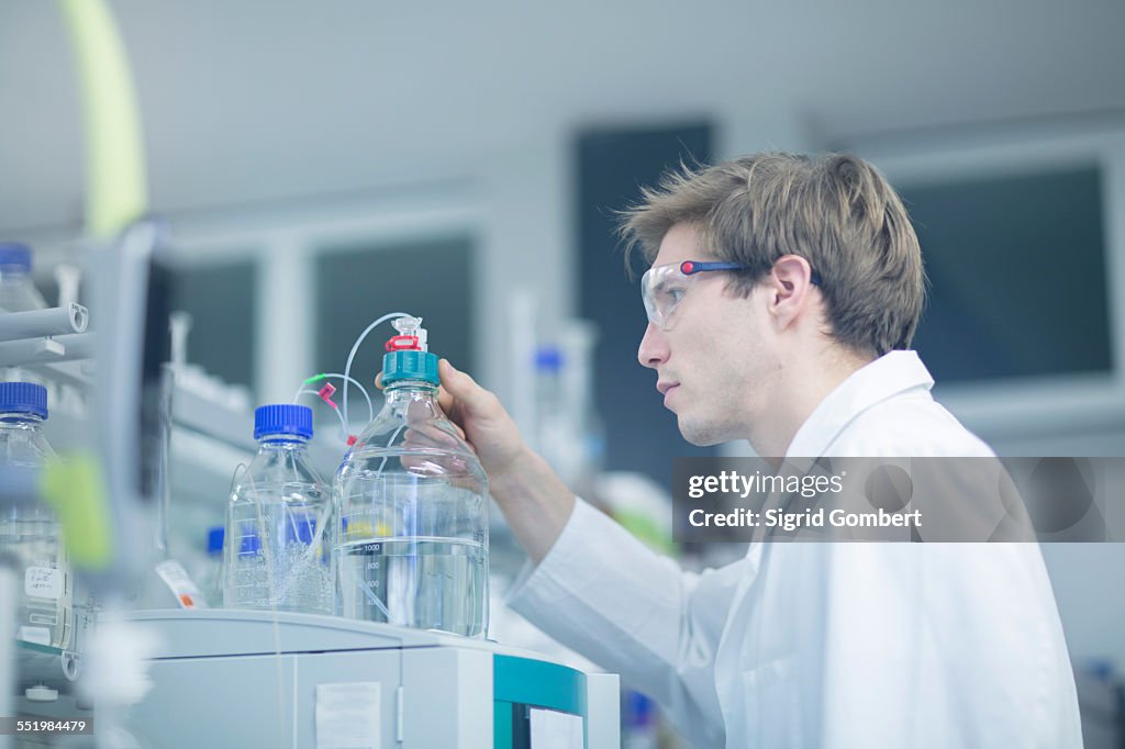 Male scientist checking experimental equipment in lab