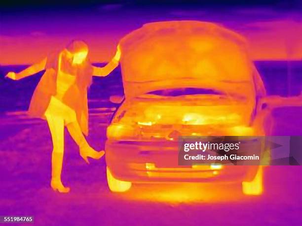 thermal image of woman kicking automobile tire on roadside - kicking tire stock pictures, royalty-free photos & images