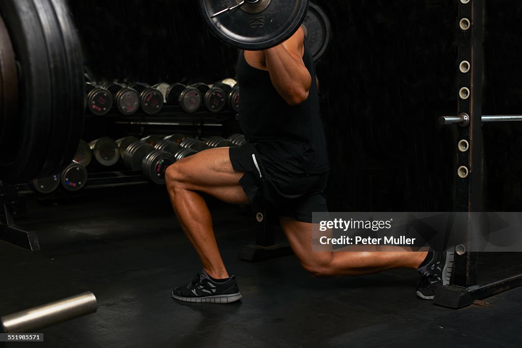 Mid adult man, lifting weights, low section