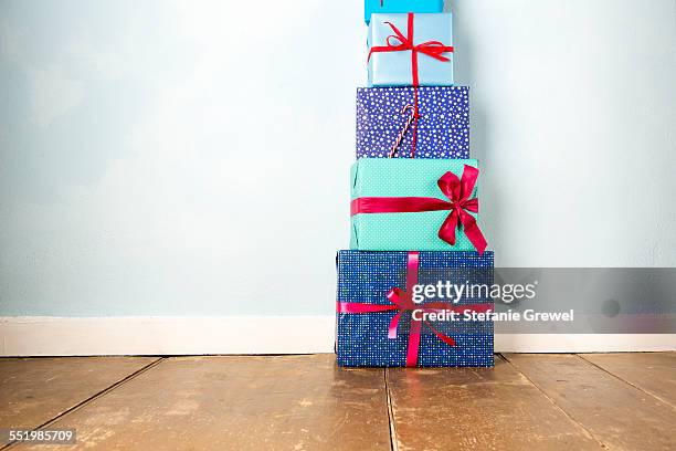 stack of five wrapped christmas gifts on wooden floor - bavaria christmas stock pictures, royalty-free photos & images