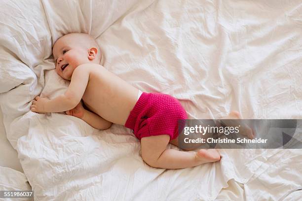 baby girl rolling and playing on bed - de rola imagens e fotografias de stock