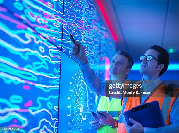 geologists studying graphical display of oil and gas bearing rock on screens - team analysing stock pictures, royalty-free photos & images