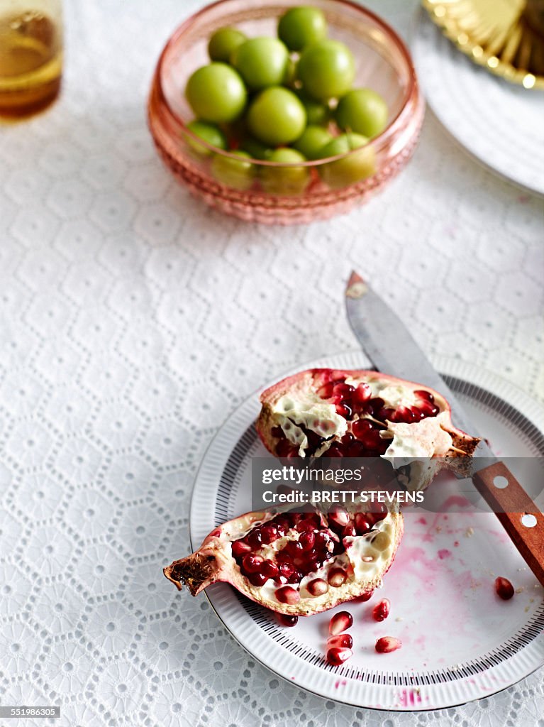 Still life with pomegranate and a bowl of green olives