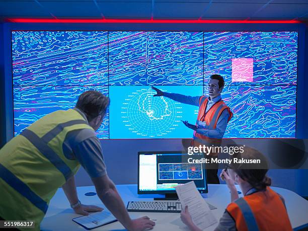 geologists studying graphical display of oil and gas bearing rock on screens - geologist ストックフォトと画像