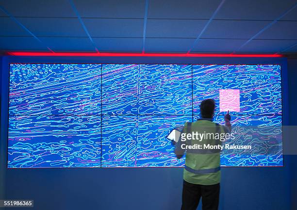 geologist studying graphical display of oil and gas bearing rock on screens - geoloog stockfoto's en -beelden