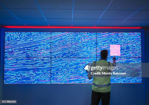 geologist studying graphical display of oil and gas bearing rock on screens - 地質學 個照片及圖片檔