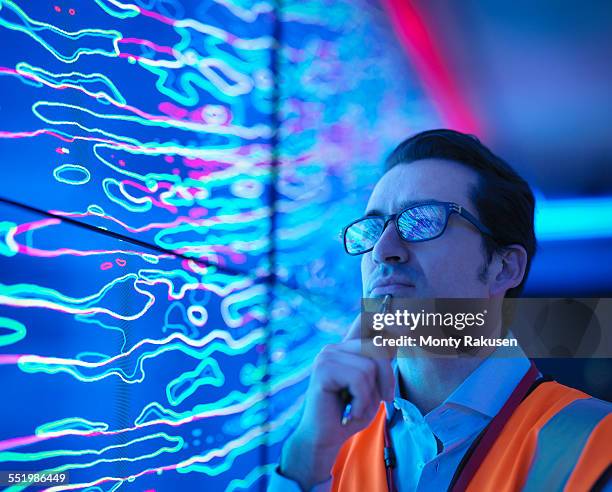 geologist studying graphical display of oil and gas bearing rock on screens, close up - geoloog stockfoto's en -beelden