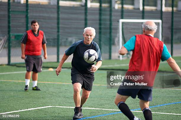 men playing football - old people playing football stock pictures, royalty-free photos & images