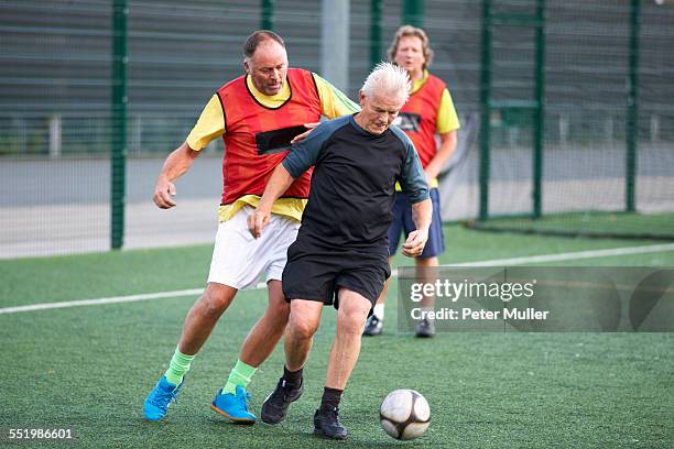 men playing football - senior kicking stock pictures, royalty-free photos & images