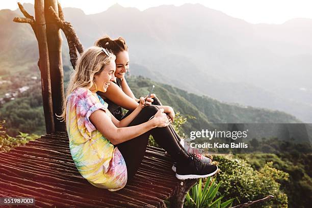 two young female friends on balcony over lake atitlan, guatemala - sabbatical stockfoto's en -beelden