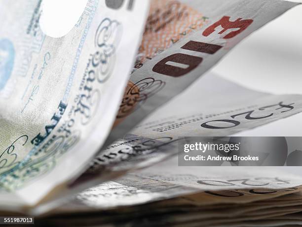 close up detail of a stack of british banknotes - bribing stockfoto's en -beelden