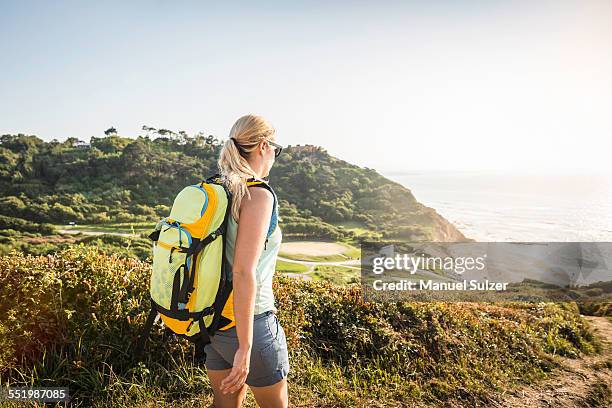 young woman hiking on coastal path, erretegia beach, bidart, france - pays basque stock pictures, royalty-free photos & images