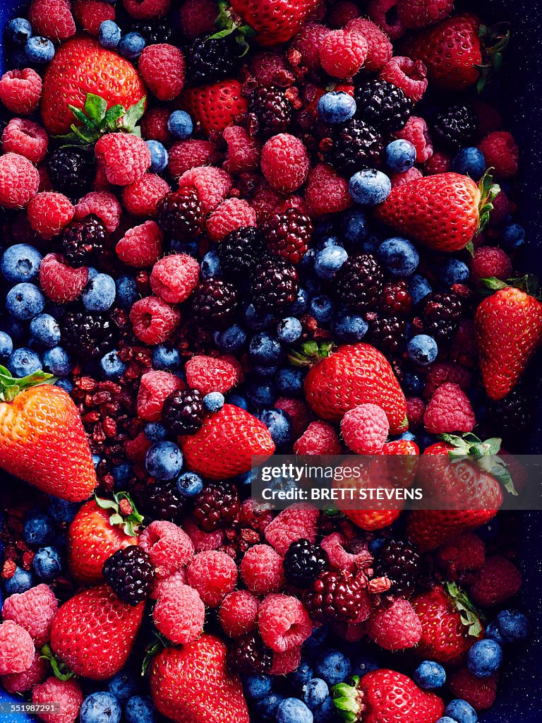 Still life with abundance of strawberries, blackberries, blueberries, raspberries and cranberries