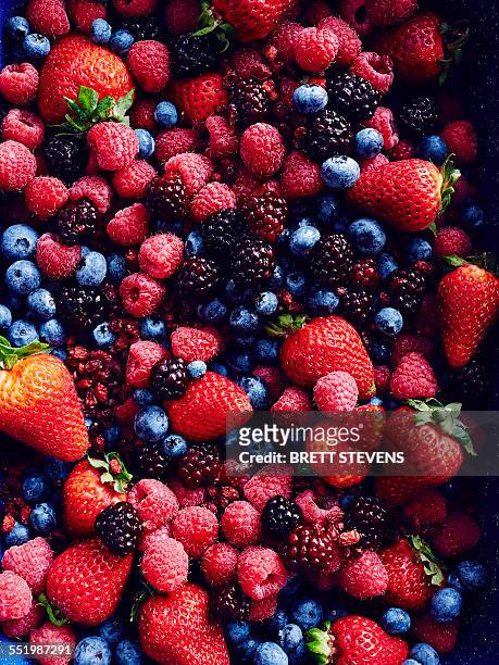 still life with abundance of strawberries, blackberries, blueberries, raspberries and cranberries - summer fruit stock pictures, royalty-free photos & images
