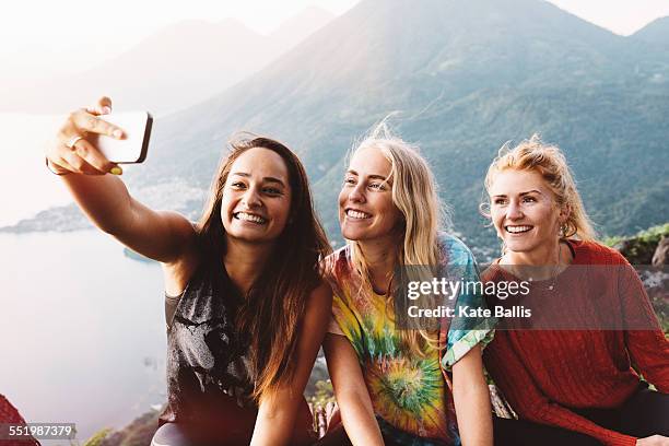 three female friends taking smartphone selfie at lake atitlan, guatemala - selfie three people stock pictures, royalty-free photos & images