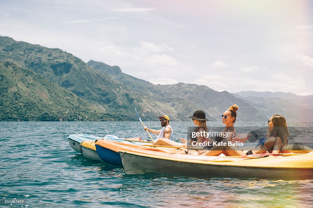 Four young adult friends kayaking on Lake Atitlan, Guatemala