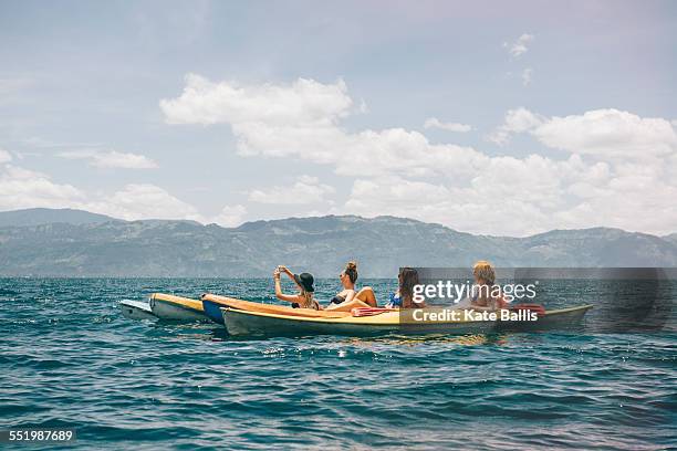 four young female friends kayaking on lake atitlan, guatemala - lake atitlan - fotografias e filmes do acervo