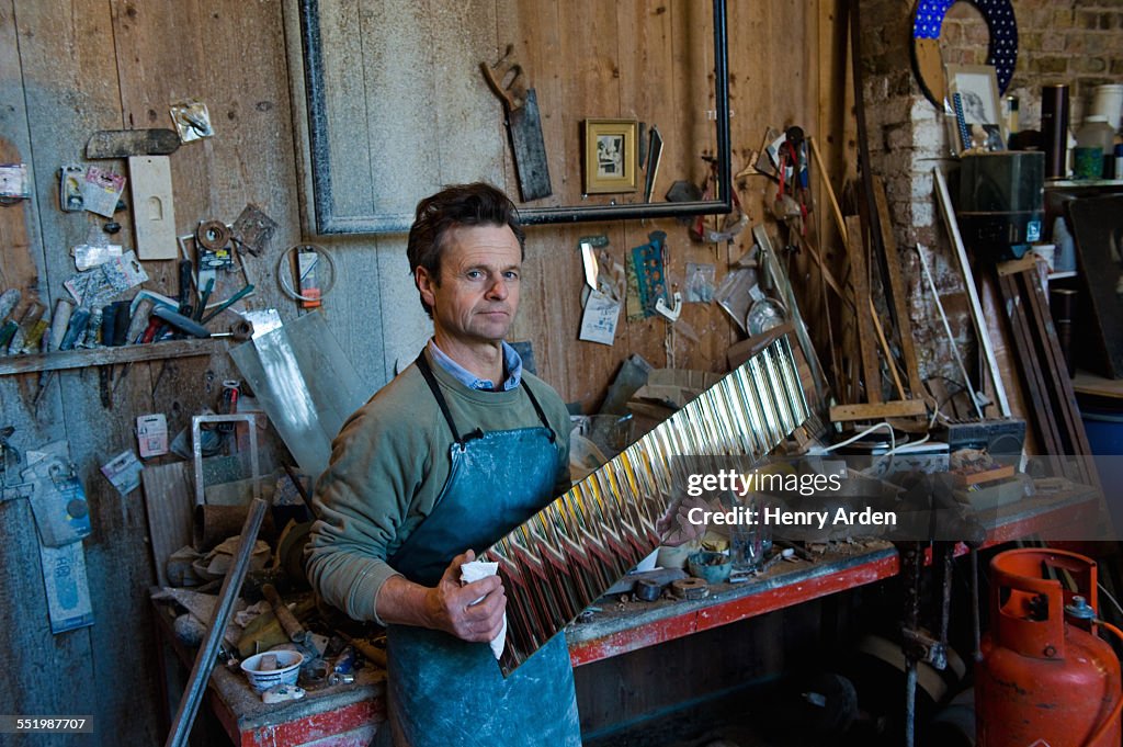 Portrait of glass engraver holding polished glass material in workshop