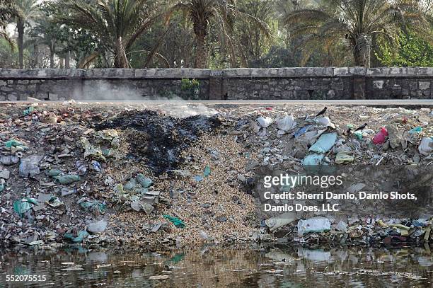trash pile on fire in cairo - damlo does stock-fotos und bilder