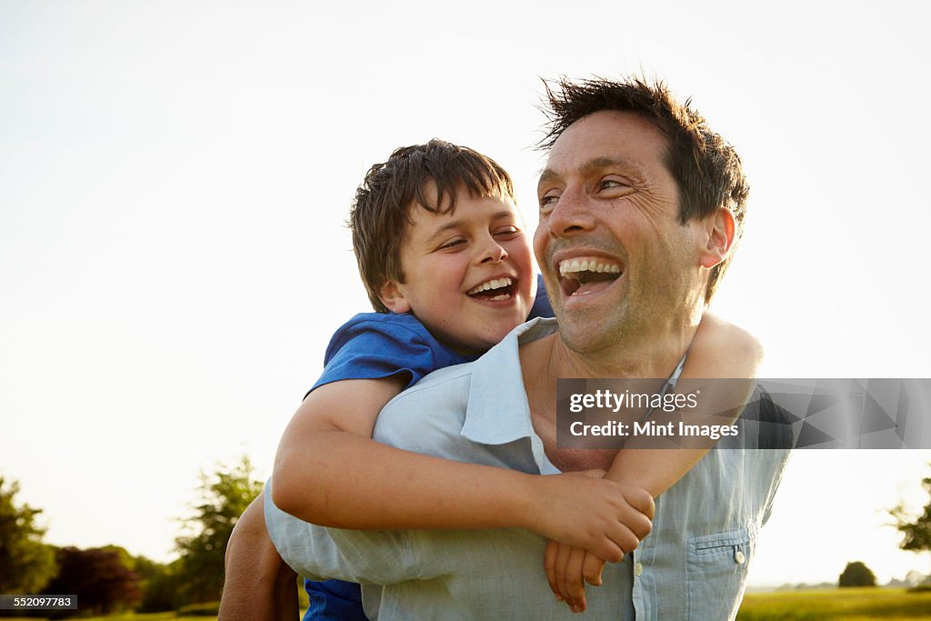 A father giving his son a piggyback.