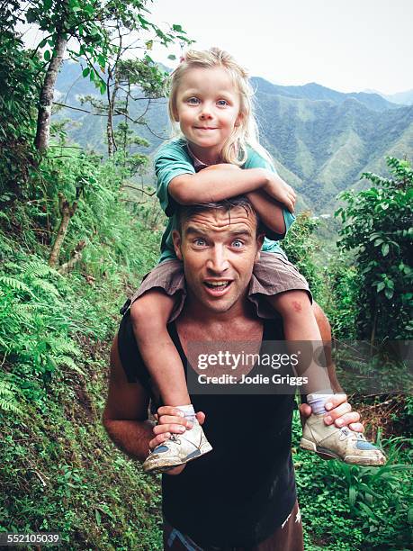 father giving child a shoulder ride whilst hiking - over the shoulder view stockfoto's en -beelden