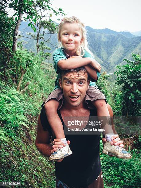 Father giving child a shoulder ride whilst hiking