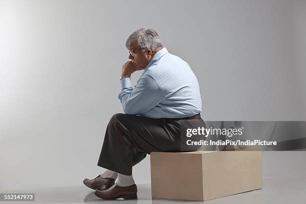 obese old man thinking - fat man sitting stock pictures, royalty-free photos & images