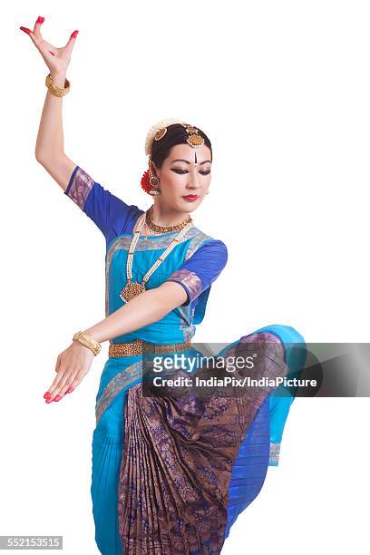 dancer posing while performing bharatanatyam against white background - bharatanatyam dancing stock pictures, royalty-free photos & images
