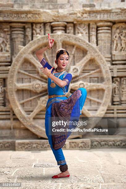 full length of bharatanatyam dancer performing against carved wall - bharat natyam foto e immagini stock