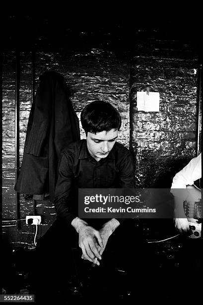 Singer Ian Curtis of rock group Joy Division, at TJ Davidson's rehearsal room, Little Peter Street, Manchester, 19th August 1979. On the right is...