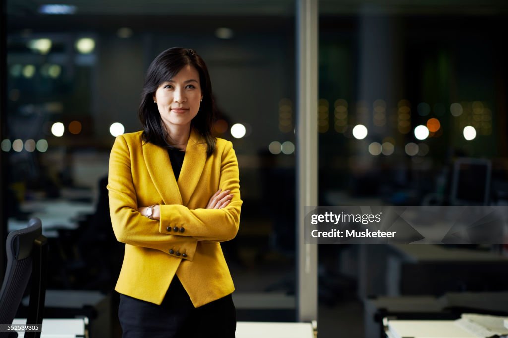 Woman standing in office at night